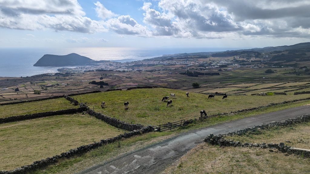 Panoramic farmland roads on Terceira Island with volcanic landscapes and stone walls.